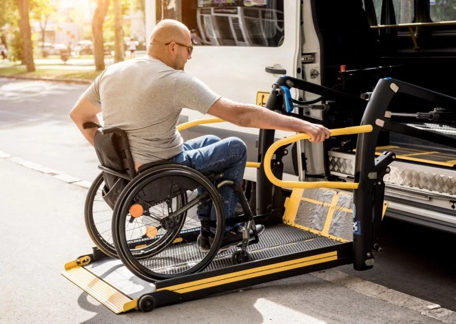 Man in wheelchair using ramp to access van