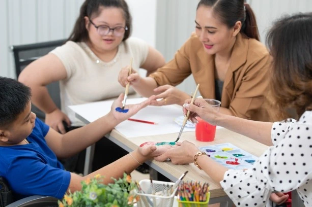 Group of disabled people with carer in art class